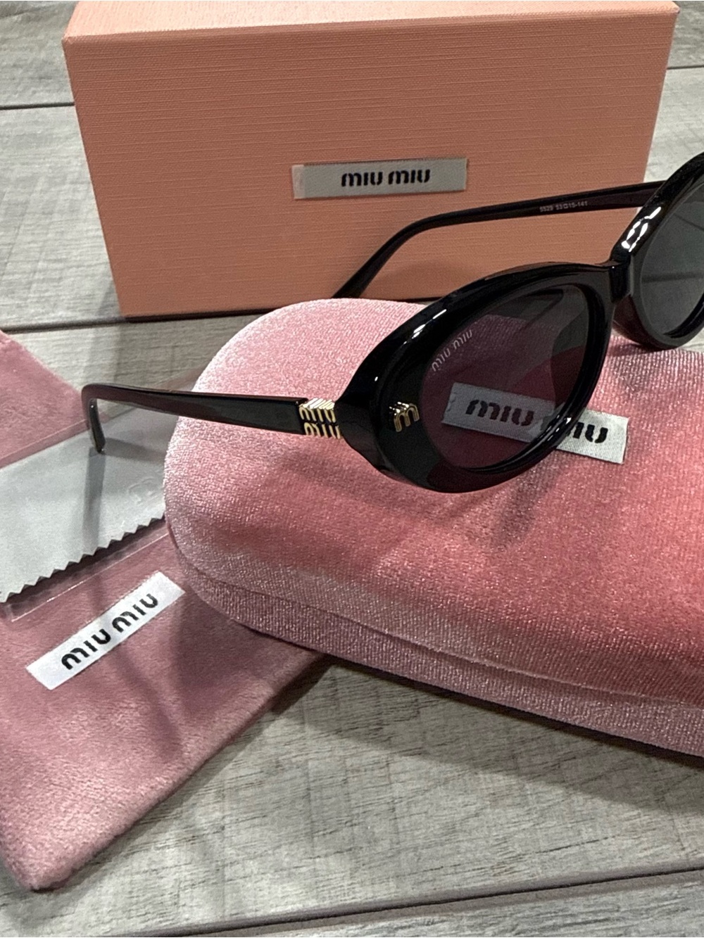 Miu Miu Glossy Black Cat-Eye Sunglasses with Gold Accents